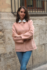 a lady in a pink wool jacket and a pair of jeans